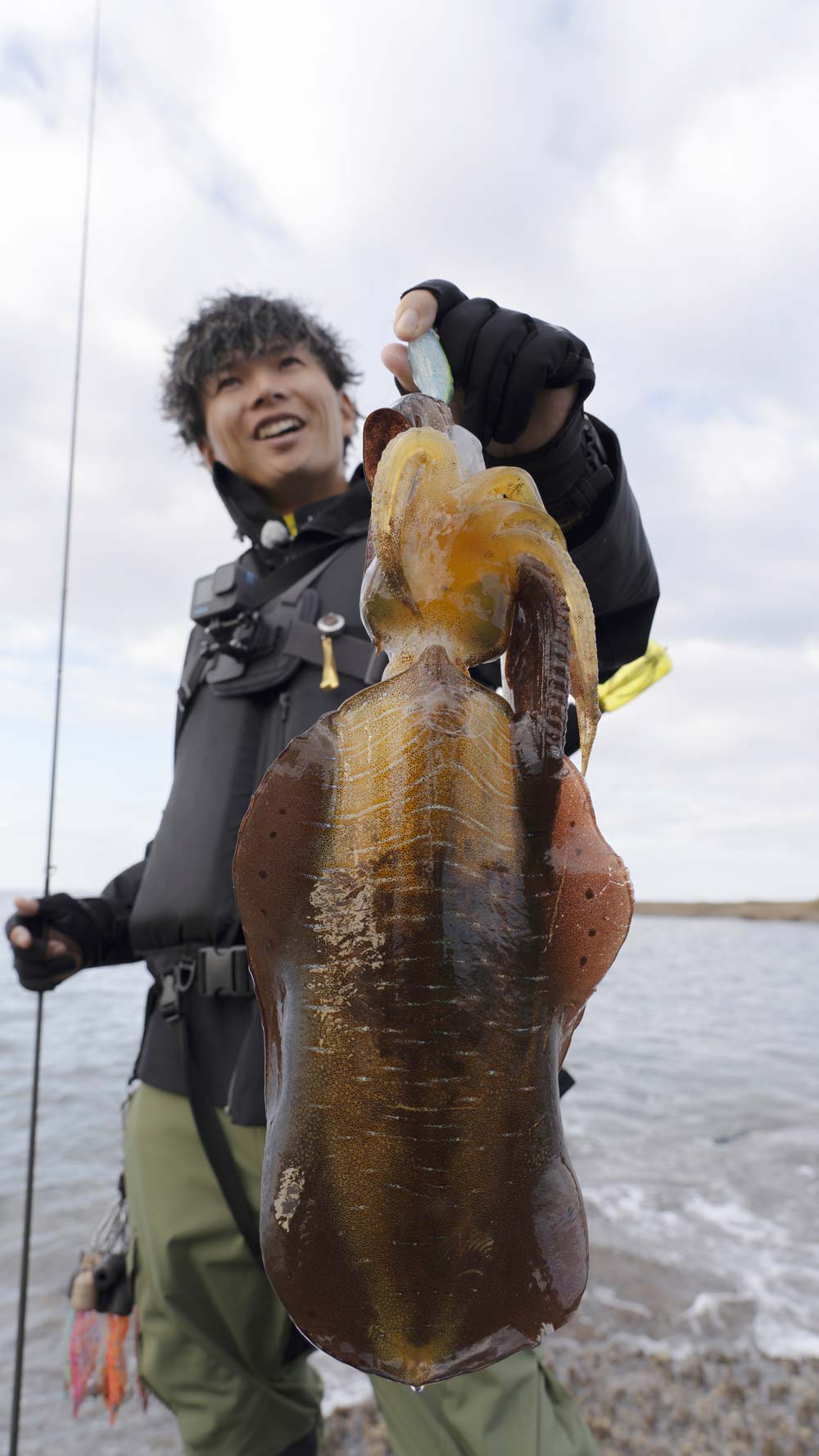 釣り上げたビッグサイズのアオリイカを掲げ、笑顔を見せる勝股