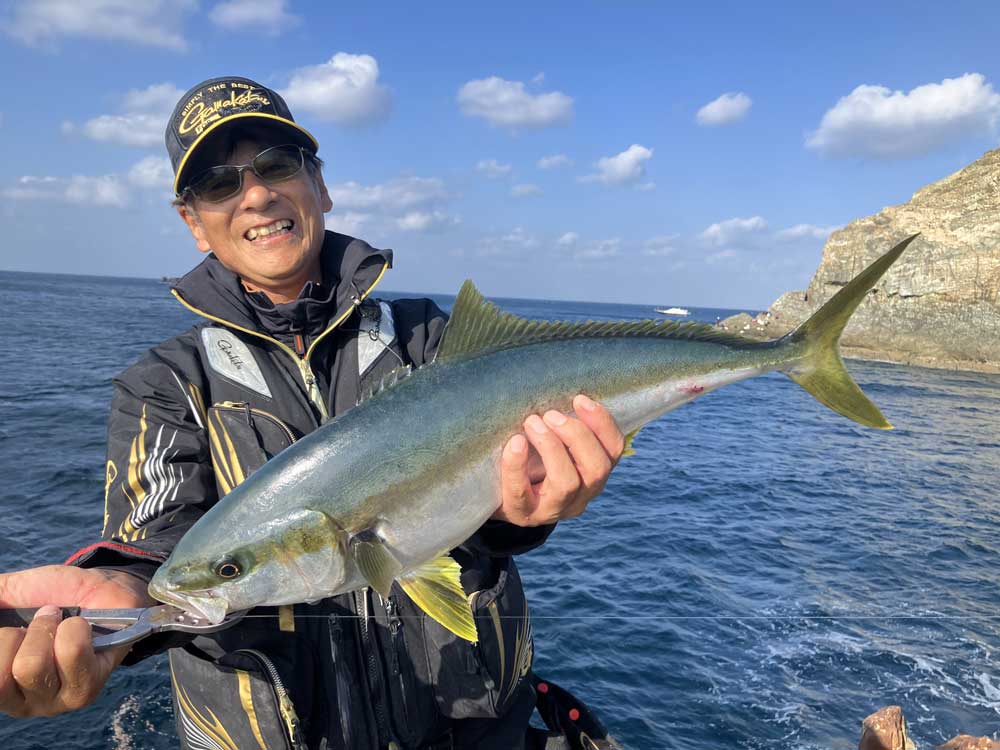 釣り上げた70cmのヒラマサを手に、笑顔を見せる北村