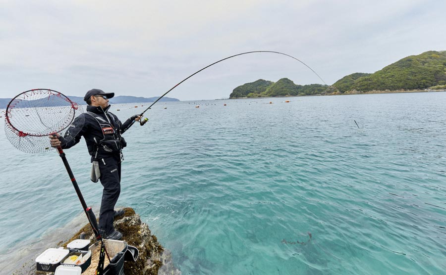 タモ網を右手に持ち、左手で竿を操作する沖永