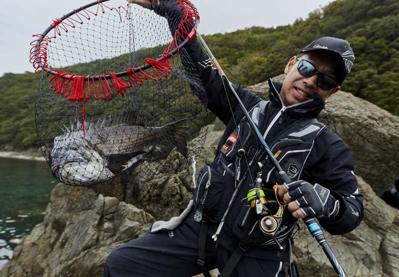 タモに収まったチヌを掲げ、笑顔を見せる沖永