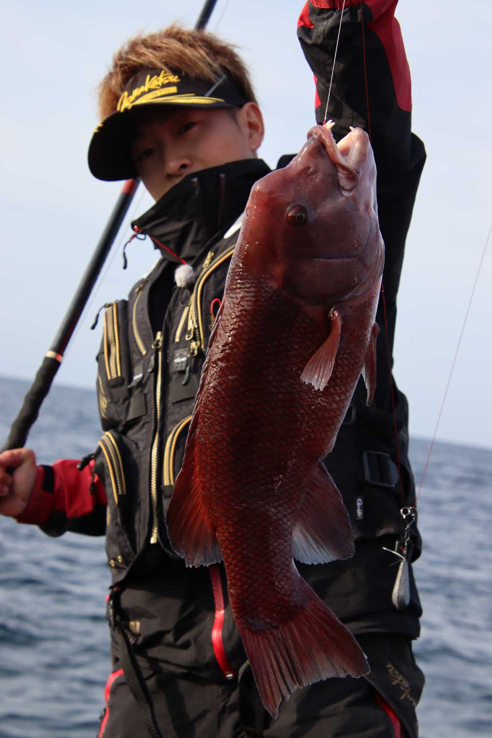 釣り上げたコブダイを掲げる大野