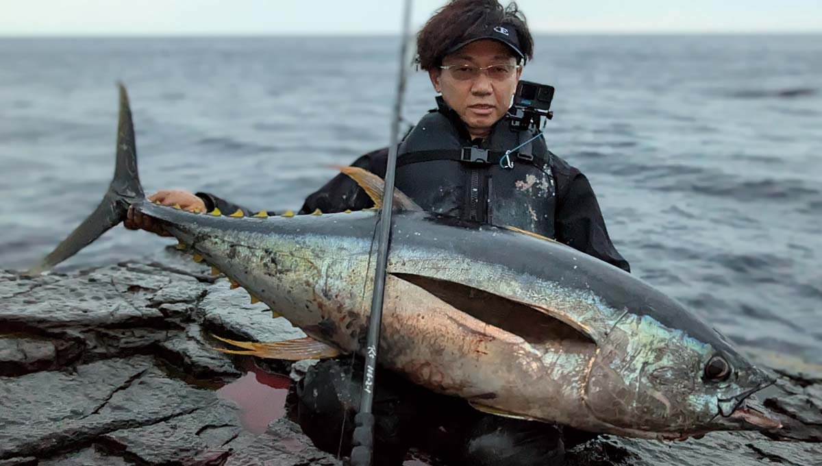 釣り上げた大魚を両膝に乗せているアングラー